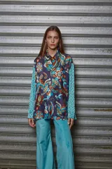 Camisa holgada estampada con motivos paisley en tonos marrón, beige y azul. Tiene cuello solapa, mangas largas y cierre frontal con botones.