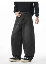 Pantalón de jean negro con lavado oscuro y efecto desgastado, de corte muy ancho (baggy) y tiro medio/alto con cintura elástica. Presenta bolsillos delanteros y traseros.