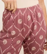 Conjunto de pijama de viscosa con estampado de caracolas, compuesto por una blusa de breteles finos con encaje en el escote, un pantalón capri con cintura elástica y una bata con lazo delantero.