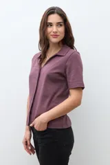 Camisa de manga corta color ciruela, con cuello camisero y cierre frontal de botones.