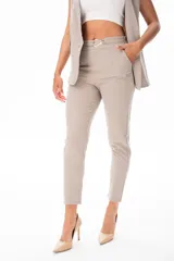 Pantalón de vestir color beige, con corte recto, bolsillos laterales y cinturón con hebilla metálica.