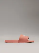 Ojotas color salmón con logo Calvin Klein Jeans en blanco.