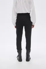 Pantalón negro de vestir, corte slim fit y largo al tobillo.