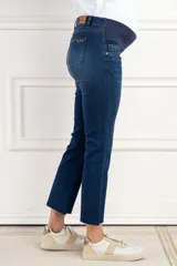 Pantalón de jean azul de corte flare, tiro medio y pretina maternal elástica.