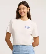 Remera de algodón color blanco tiza, manga corta y cuello redondo. Presenta un estampado grande en la espalda con la palabra "Creative" en tipografía cursiva iridiscente, un oso de goma con efecto holográfico en tonos azules y rosados, y el texto "MATTERS MORE THAN P¡FORMACE" debajo.