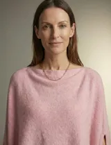 Poncho tejido de punto grueso, color mostaza/mostaza oscuro, con cuello redondo y caída amplia.