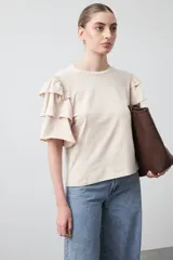 Remera negra de algodón con cuello redondo y mangas cortas con volados en capas.