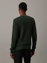 Sweater verde oscuro de algodón orgánico con textura de piqué micro, cuello redondo y logo 'ck' bordado en el pecho.