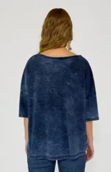 Remera color amarillo con cuello redondo y mangas cortas amplias, con detalle de botones en los laterales.