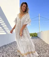 Vestido túnica largo de color celeste con bordados dorados y detalles de encaje en el escote y ruedo.