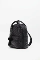 Mochila negra con diseño matelaseado, correa ajustable y manijas para llevar al hombro. Tiene cierre de cremallera, accesorio colgante decorativo, bolsillo interno y espacio para laptop.