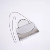 Cartera de mano tipo sobre, color plateado, con textura de escamas y cadena metálica plateada desmontable.