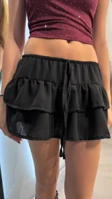 Short pollera negro con volados y cintura elastizada con cordón ajustable.