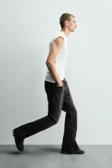 Pantalón de jean celeste, de tiro medio, corte ajustado en la parte superior y acampanado desde la rodilla. Tiene cinco bolsillos, efecto lavado y bajo irregular.