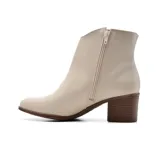 Bota corta de cuero negro con taco alto y hebilla dorada decorativa.