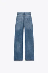 Pantalón de jean celeste de corte wide leg y tiro alto, con cinco bolsillos y cierre frontal con cremallera y botón metálico.