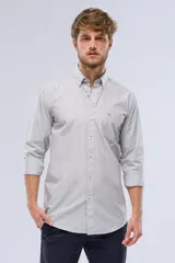 Camisa celeste a rayas verticales, de manga larga con opción de enrollar, corte slim fit, con bolsillo en el pecho y confeccionada en algodón.