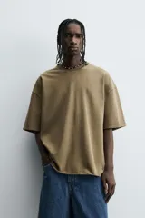 Camiseta color beige de corte holgado, cuello redondo y manga corta.