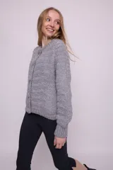 Cárdigan tejido a crochet color gris, con cuello redondo, mangas abullonadas, botones grandes y terminaciones acanaladas.