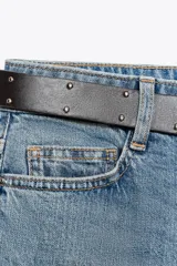 Pantalón de jean celeste de corte recto, tiro medio y cinco bolsillos. Incluye cinturón negro con hebilla plateada.