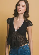 Top de encaje negro con escote en V, mangas cortas y detalle de moña blanca en el centro.