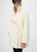 Abrigo blanco de lana virgen con diseño oversize, cuello de solapa y cierre de doble botonadura.