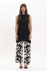 Pantalón ancho de tejido de punto, color amarillo claro con estampado floral grande en blanco.