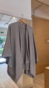 Ruana gris de tejido de punto con caída irregular.