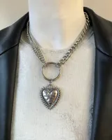 Gargantilla de acero quirúrgico plateado con dije de corazón con rayos y estrella.