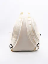 Mochila de tela color crema con bolsillo frontal con cordón ajustable, bolsillos laterales y correas de tela.