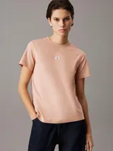 Remera color salmón de algodón con cuello redondo, mangas cortas y logo de Calvin Klein en el pecho.