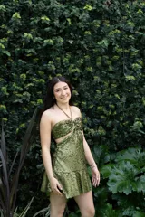 Vestido corto de fiesta color verde esmeralda brillante, con escote strapless, argolla metálica en el busto, breteles finos y cut-outs en el delantero.