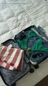 Bikini de dos piezas color verde esmeralda, con acabado de terciopelo o tela brillante. El corpiño es triangular con tirantes finos ajustables y la parte inferior es de corte clásico con tiras laterales ajustables.