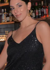 Vestido corto negro con lentejuelas y breteles finos.