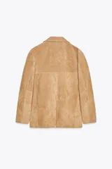 Blazer color camel confeccionada en piel de ante 100%. Diseño clásico con cuello solapa, escote pico, manga larga, bolsillos con solapa en delantero, forro interior combinado, bajo con abertura en espalda y cierre frontal con botones.