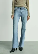 Pantalón de jean celeste de corte acampanado, tiro medio y bajo deshilachado.