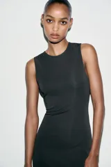 Vestido largo negro de cuello redondo y sin mangas. Tejido combinado a tono en espalda.