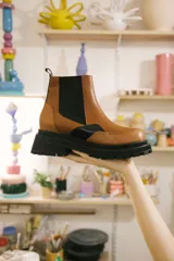 Bota Chelsea color marrón con elástico lateral negro y suela track negra.