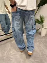 Pantalón de jean celeste, corte ancho, estilo cargo con bolsillos laterales.