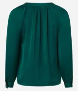 Blusa verde esmeralda de tela satinada, con escote en V, mangas largas con puños abotonados y espalda fruncida.