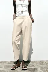 Pantalón bombacho color beige de lino, con cintura elástica, bolsillos frontales y bolsillos de parche en la espalda.