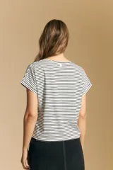 Remera de manga corta con cuello redondo, confeccionada en tejido acanalado a rayas horizontales blancas y negras.
