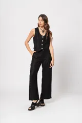 Conjunto negro brillante de chaleco con botones y pantalón palazzo de tiro alto con bolsillos.