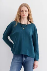Remera blanca de algodón con calce relajado y cuello redondo. Tiene mangas largas que se ajustan hacia los puños.