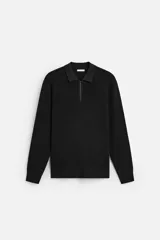Polo negro de punto con cuello solapa y cierre frontal de cremallera.