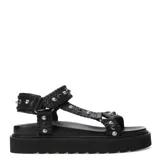 Sandalias bajas color tostado, con plataforma y tiras de cuero sintético con tachas doradas y negras.