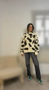 Sweater de lana merino con cuello redondo y diseño con motivos geométricos en tonos azul, marrón, naranja, verde y beige.