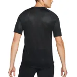 Camiseta deportiva Nike Academy negra con estampado degradado de puntos blancos en el frente y logo triangular con swoosh amarillo.