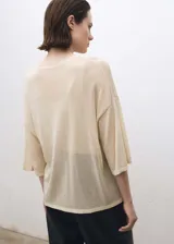 Jersey de punto fino color crema, de manga corta, cuello redondo y corte oversize.