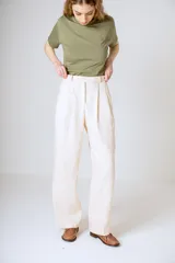 Pantalón negro de corte ancho y tiro alto, con pinzas en la cintura y bolsillos laterales.